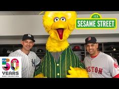 two men standing next to each other in front of a sesame street sign and mascot