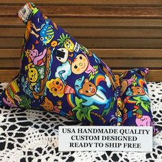 a colorful triangle shaped object on top of a doily next to a sign that says usa handmade quality custom designed ready to ship free