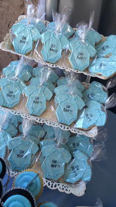 cupcakes and cookies are on display in plastic wrappers at a baby shower