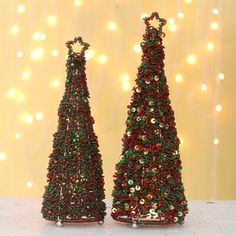 two small christmas trees are sitting on a table