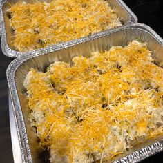 two metal pans filled with food covered in cheese