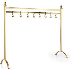 a gold coat rack with five hooks and two coats hanging from it's sides