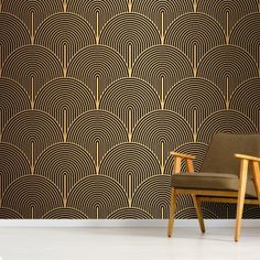 two chairs in front of a wall with black and gold art deco design on it