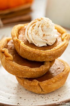 a stack of pumpkin pies with whipped cream on top