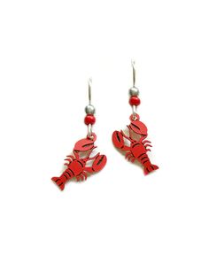 lobster earrings with red beads hanging from hooks on a white background, the image is made out of wood