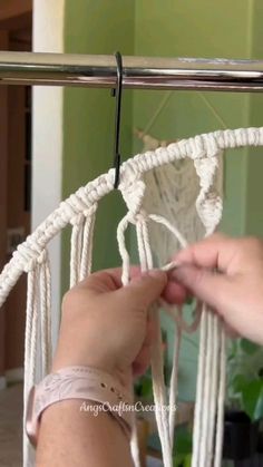 the person is making a piece of white rope