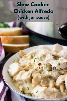 slow cooker chicken alfredo with jala sauce on a white plate next to bread