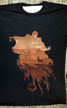 a black t - shirt with an image of a deer in the middle of it