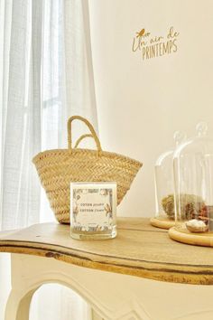 a wicker basket sitting on top of a wooden table next to a glass dome