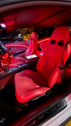 the interior of a car with red leather seats