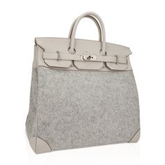 Guaranteed authentic rare Hermes HAC 40 bag featured in Gris Clair Todoo Feutre (Wool) and Craie Togo leather.A chic and masculine combination for this rare Hermes classic bag.Beautiful light gray and Craie combination this tote bag is neutral perfection for everyday to travel wear. This Hermes Hac bag is accentuated with crisp palladium hardware.There is a mark on the front flap - please see image.Comes with lock, keys and clochette and sleeper.The HAC (Haut à Courroies) is an extremely rare an Hermes Travel Bag, Birkin 40, Travel Wear, Kelly Bag, Togo Leather, Birkin Bag, Elegant Fashion, Light Gray, Travel Bag