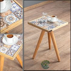 there is a small wooden table with two cups on it and a plate next to it