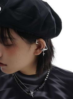 a woman wearing a black hat and ear cuff