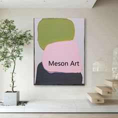 a painting hanging on the wall next to a potted plant in a living room