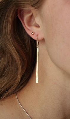 "These lovely earrings are handmade from 14k yellow recycled gold and are 2.25 \" total length from the top of the lever back wire. The long slender stick of gold hangs from a soldered circle for easy movement and style. I have used lever backs because they are very secure and comfortable to wear. The plain lever back compliments this modern design. They speak for themselves, not much to say but wow 3 grams total weight made with recycled 14k gold. Available in 14k white, yellow, or rose gold. M Gold Thread Earrings, Earring Bar, Long Bar Earrings, Trendy Stud Earrings, Earrings Dangle Simple, Gold Bar Earrings, Stick Earrings, Long Gold Earrings, Wedding Earrings Drop