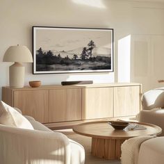 a living room filled with furniture and a painting hanging on the wall over a coffee table