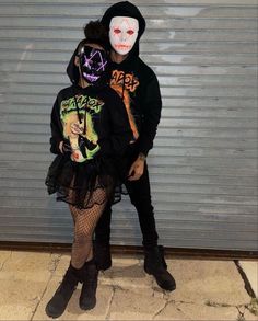 two people dressed up in costumes standing next to each other with their faces painted on