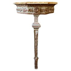 an ornate pedestal with a marble top and metal base, on a white background for display