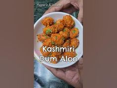 a hand holding a white bowl filled with food and the words kashmiri dum aloo