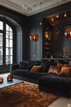 a living room filled with black furniture and lots of lights hanging from the ceiling above it