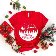 Celebrate the magic of Christmas with this charming t-shirt featuring a classic holiday scene! This festive design showcases Santa Claus with his reindeer surrounded by a winter forest, all beneath the cheerful message "Merry Christmas." Perfect for those who love the holiday season and want to spread joy wherever they go. Made from soft, comfortable fabric, this shirt is ideal for wearing to holiday parties, family gatherings, or any festive occasion. Get ready to embrace the spirit of Christmas in style! Our designs are tailored for various colors: Black designs are ideal for White, Athletic Heather, Orange, Pink, Baby Blue, Natural, and Heather Peach. For all other colors, White designs are recommended. *  Unisex, Youth, Toddler, T-shirts and Baby Onesies are  crafted from 100% Airlume Red Letter Print Shirt For Gift, Red Letter Print T-shirt For Gift, Red Letter Print T-shirt As Gift, Red T-shirt With Letter Print As Gift, Red Screen Print Tops As Gift, Red Screen Print Tops As A Gift, Red T-shirt With Text Print For Gift, Red Graphic Print Shirt For Gift, Graphic Print Red Shirt For Gift