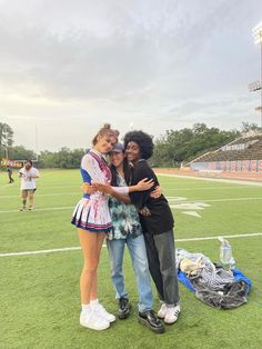 two young women hugging each other on a football field