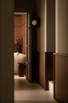 an open door leading to a bedroom with a bed in the corner and a plant on the wall