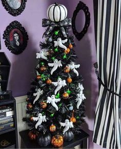 a black christmas tree with white ghost decorations