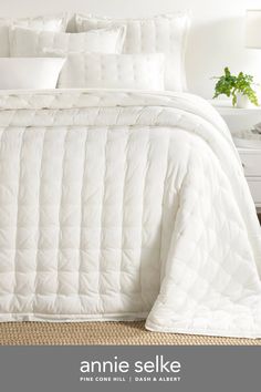 an image of a bed with white comforter and pillows