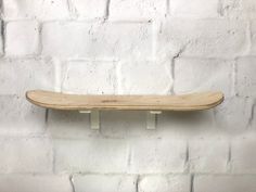 a skateboard mounted to the side of a white brick wall in front of a white brick wall