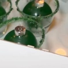 four green glass ornaments with lights on them