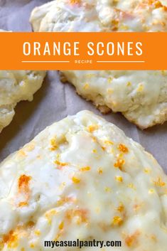 orange scones with white frosting and orange sprinkles on top are shown