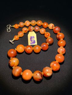 The beautiful orange color carnelian beads necklace from Himalaya Nepal This beads were used in prayer malas and used as jewelry and amulets in ancient times very smooth and shinny surface of this beads because of passage of time and usage of this beads in prayers mala and in necklace The age of this beads are more than 1000 years small size gold color brass beads are used as spacers in the necklace we provide fast and free shipping service to our customers by which can get the items by maximum Hand-strung Orange Necklace, Spiritual Carnelian Round Beads Jewelry, Spiritual Carnelian Jewelry With Round Beads, Antique Gemstone Beaded Necklace, Antique Gemstone Necklace With Round Beads, Traditional Orange Round Necklace, Orange Agate Necklace With Polished Beads, Traditional Orange Gemstone Bead Necklaces, Traditional Orange Gemstone Beads Necklace