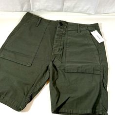 The J Brand Kontact Relaxed Slouch Green Cargo Shorts Are A Versatile And Stylish Choice For Casual Wear. With A Relaxed And Slouchy Fit, These Shorts Provide Both Comfort And A Laid-Back Vibe. The Green Color Adds A Touch Of Modernity, While The Cargo-Style Design Brings A Functional And Utilitarian Feel. Featuring A Flat Front, These Shorts Offer A Clean And Streamlined Look. The 34-Inch Waist Ensures A Comfortable Fit, Making Them Suitable For Various Casual Occasions During Warm Weather. Whe Cotton Cargo Style Shorts For Work, Casual Cargo Shorts With Patch Pockets For Work, Green Short Cargo Pants With Patch Pockets, Casual Workwear Shorts With Multiple Pockets, Casual Green Cargo Shorts With Patch Pockets, Mid-rise Cotton Cargo Shorts With Pockets, Military Style Cotton Cargo Pants With Built-in Shorts, Green Utility Short Pants, Green Short Utility Pants