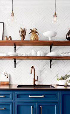 a kitchen with blue cabinets and shelves filled with dishes