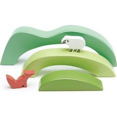 an animal figurine sitting on top of a green banana and another toy standing next to it