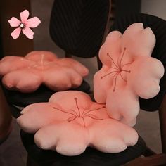 two chairs with pillows on them and a pink flower in the middle one chair has been made to look like flowers