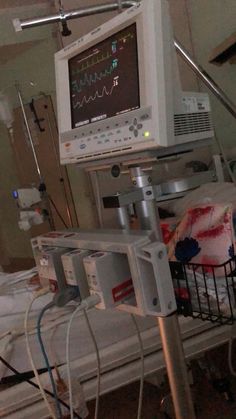 a hospital room with medical equipment and monitors on the wall, in front of a bed