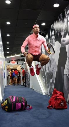 a man jumping up in the air with a tennis racquet on his feet