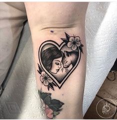 a woman's arm with a heart shaped tattoo on it and a fox in the center