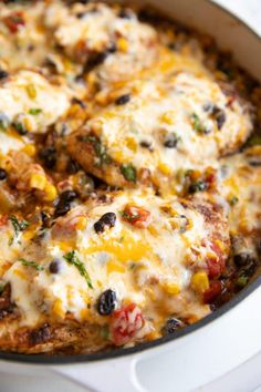 a casserole dish with chicken, black olives, and cheese on top