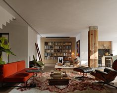 a living room filled with lots of furniture and bookshelves