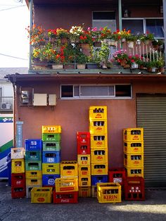 many boxes are stacked up in front of a building with flowers on the balconies