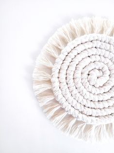 a white round rug with fringes on the top and bottom is shown in front of a white background