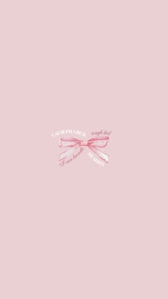 a pink wall with a bow on the top and some words written in white ink