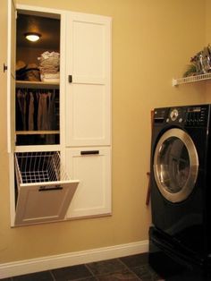 a washer and dryer sitting in a room next to a wall mounted cabinet