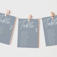 seating cards are hung on clothes pins to display the names and date for each table