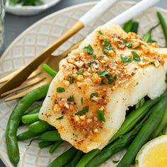 a white plate topped with fish and green beans