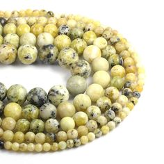 two strands of yellow and white beads with black speckles on the ends, one strand