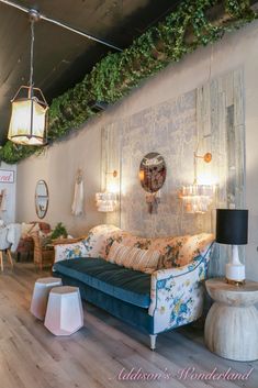 a living room filled with furniture and lots of greenery on the wall above it